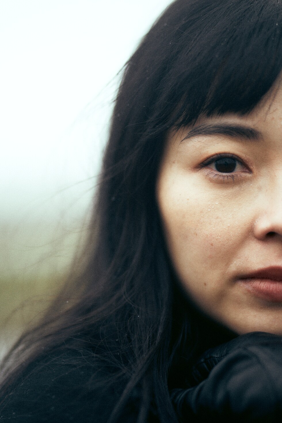 Naine vihmavarjuga vee ääres