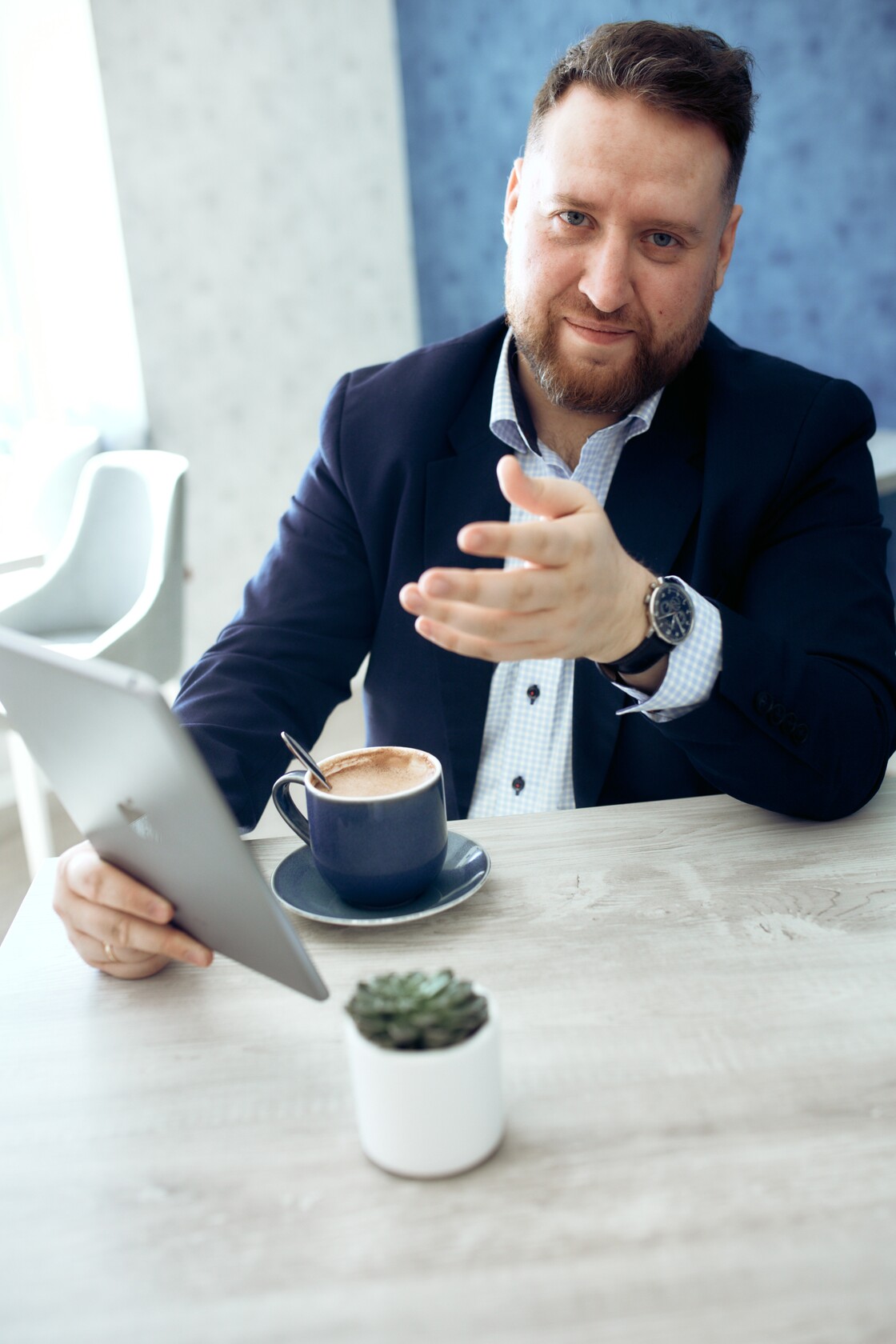 Persoonibrandi fotod ariportrid selgitab cappuccino korvalt tahvelarvuti kaes