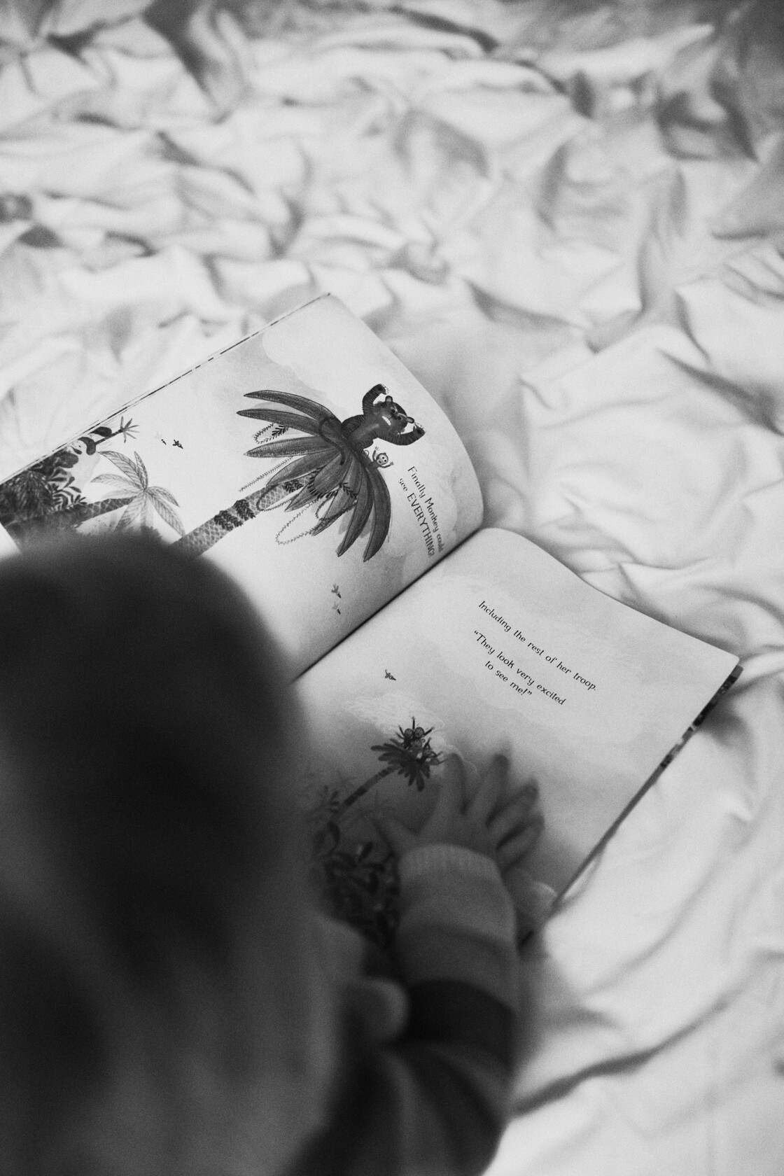 Peresessioon perefoto vaikesed sormed uurivad pildilehti voodil