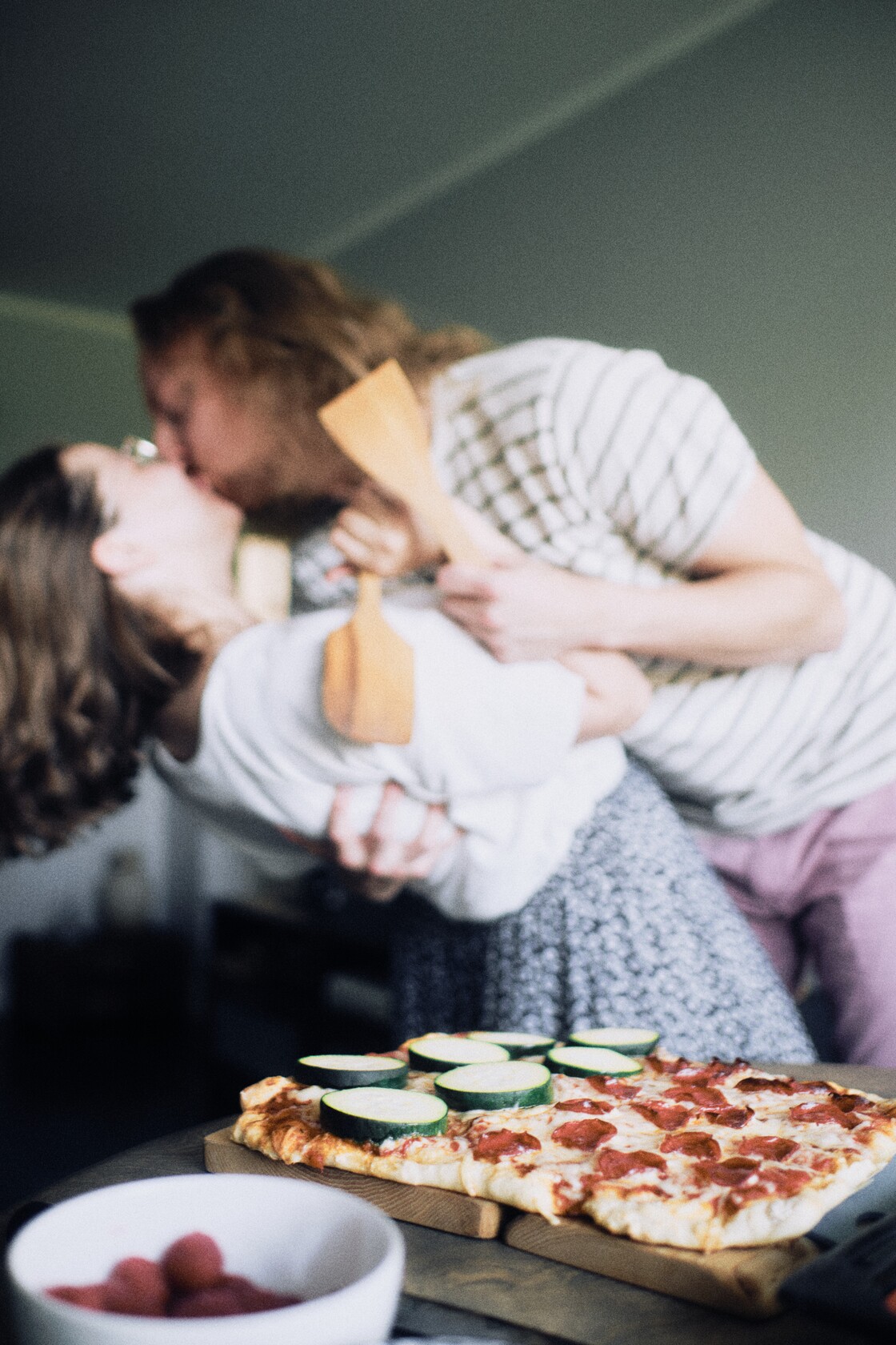 Paarifotograafia paarisessioon kallutus lusikatega varske pitsa ees