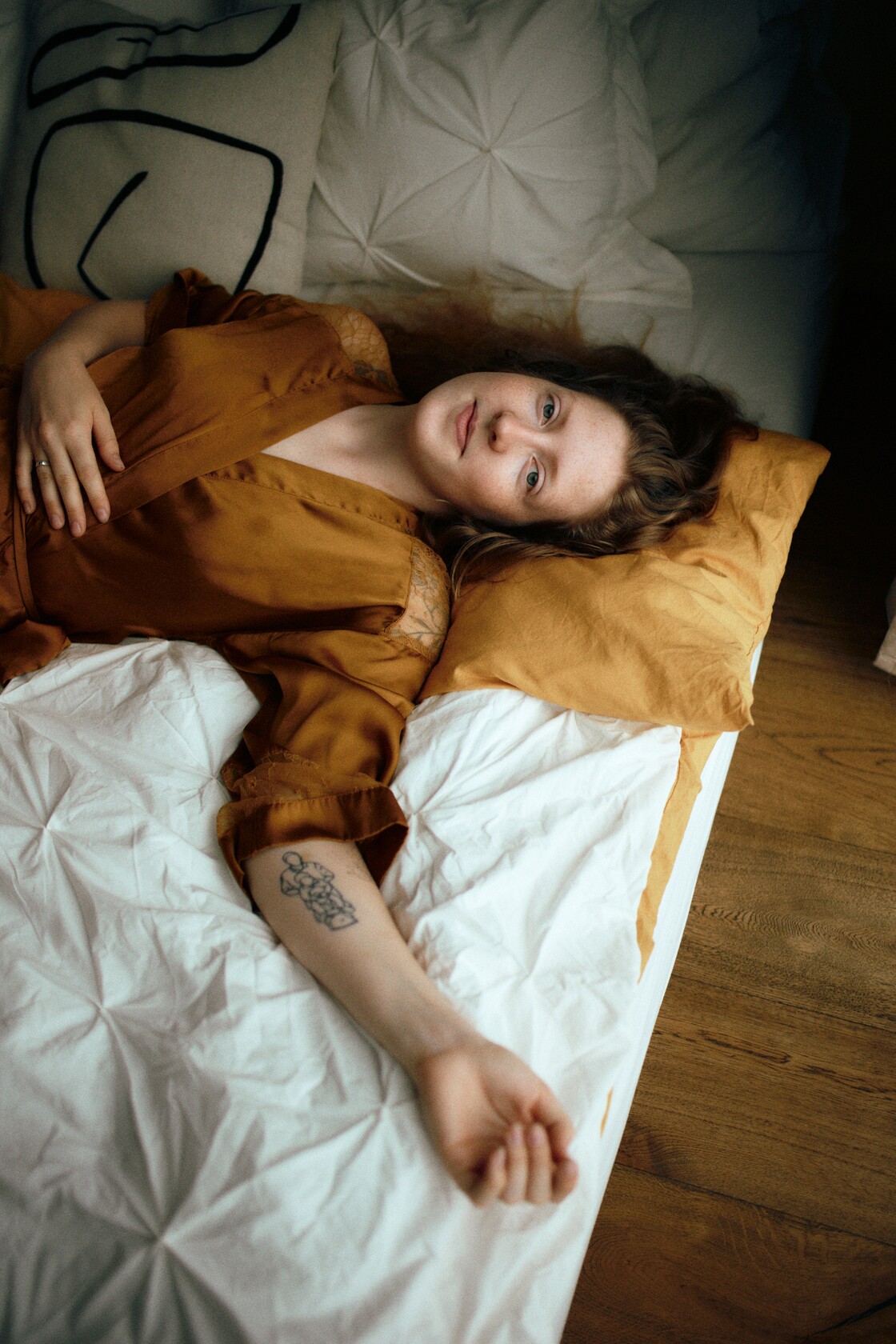 Paarifotograafia paarisessioon kuldne hommikumantel valgetel linadel