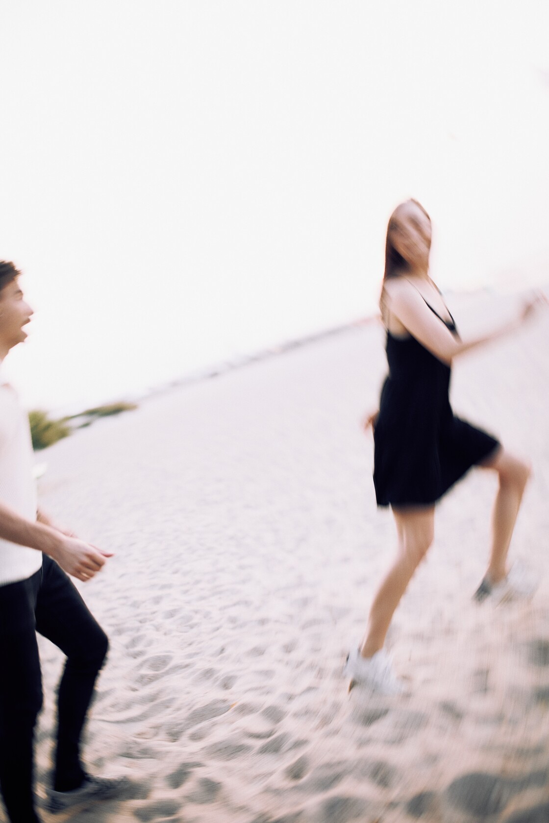 Paarifotograafia paarisessioon lustlik jooks liivarannal uduses liikumises